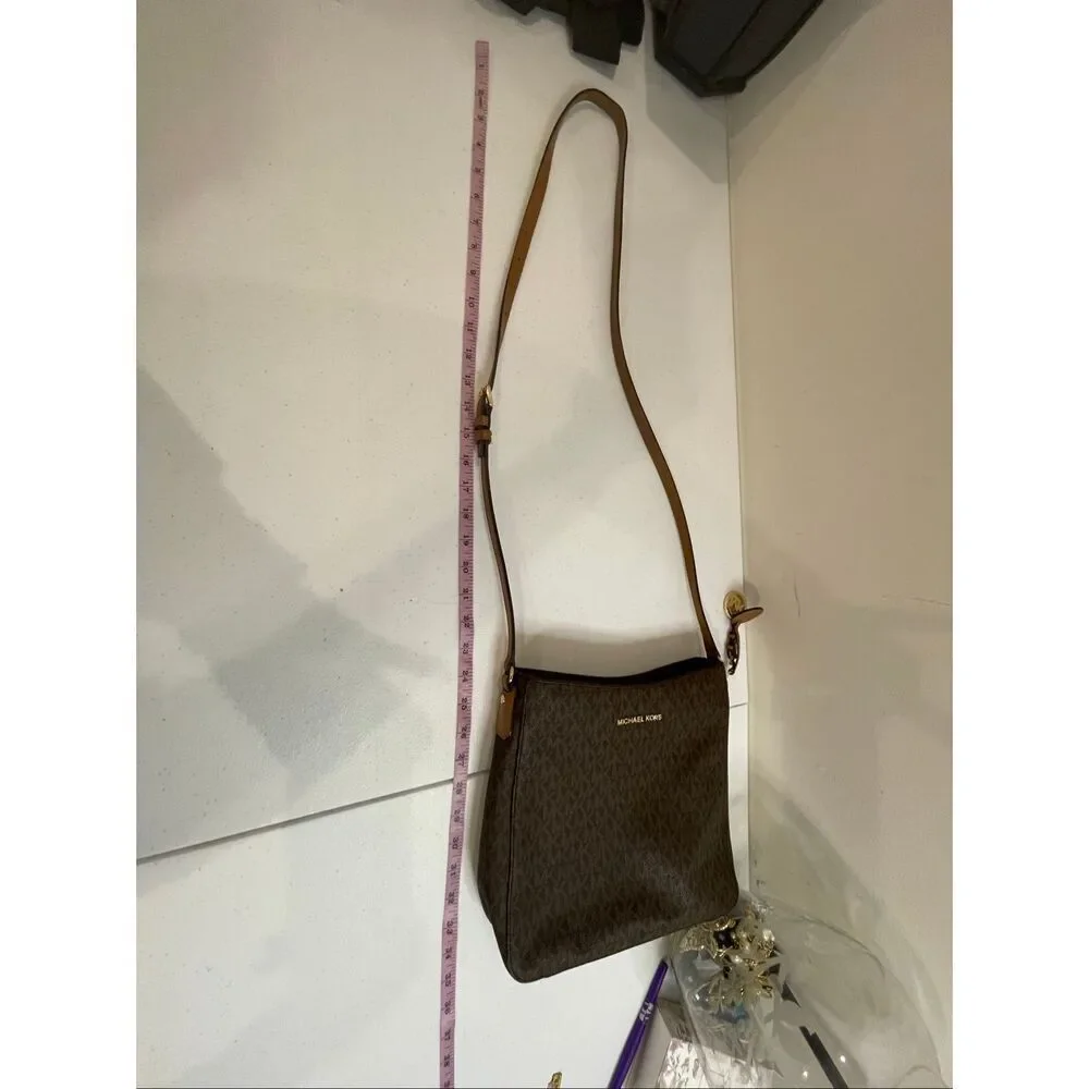 a Michael Kors Jet Set Travel Large Messenger Bag, featuring the brand's signatu